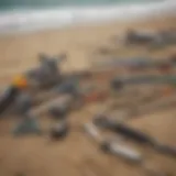 A selection of surf fishing rods and reels displayed on a sandy beach