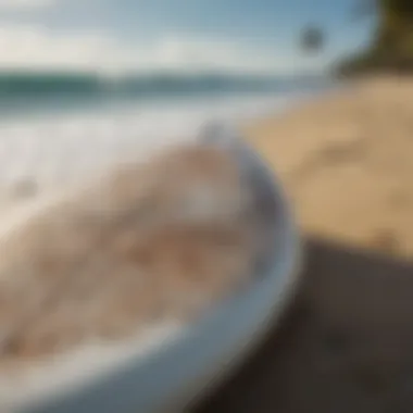 A close-up of a surfboard with intricate designs resting on the shore.