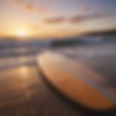 Surfboard resting on the beach at sunset