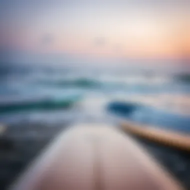 Calm ocean with surfboards on the beach at dawn