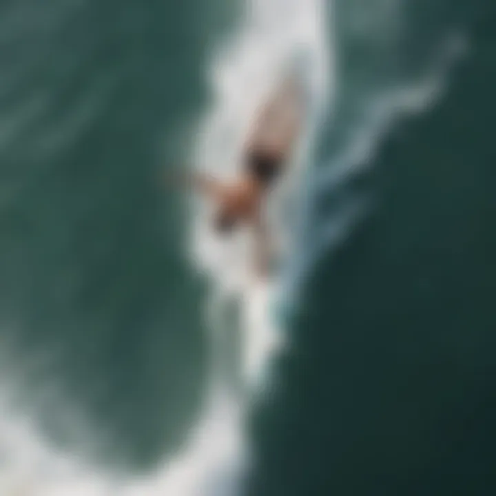 Aerial view of a surfer in mid-backflip above the water