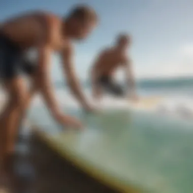 A surfer expertly waxing their board on the beach