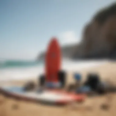 A diverse selection of surfing accessories laid out on a sandy beach