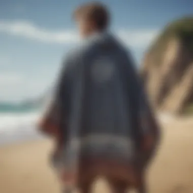 A stylish surf robe poncho draped on a sandy beach with waves in the background