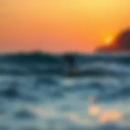 A foil surfer gliding over waves at sunset